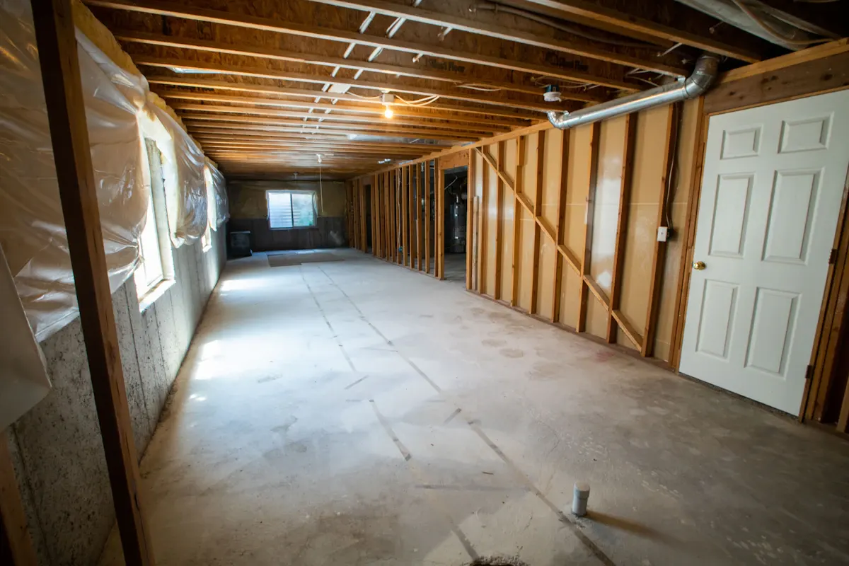 Unfinished basement with timber framing and a concrete floor