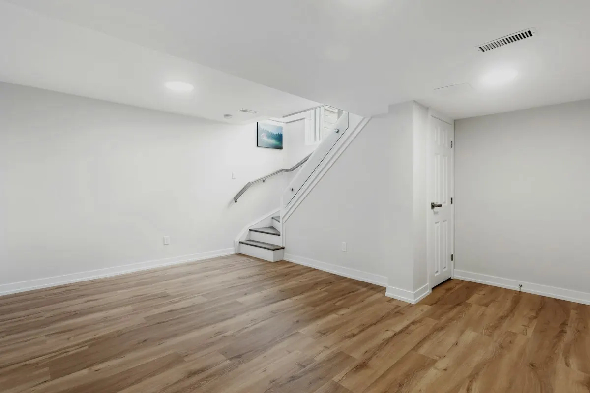 Finished basement stair with a white railing